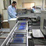 An employee is seen on the production line of the solar energy department at the Arab International Optronics factory on the outskirts of Cairo
