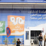 Customers and security guards stand in front of a branch of the